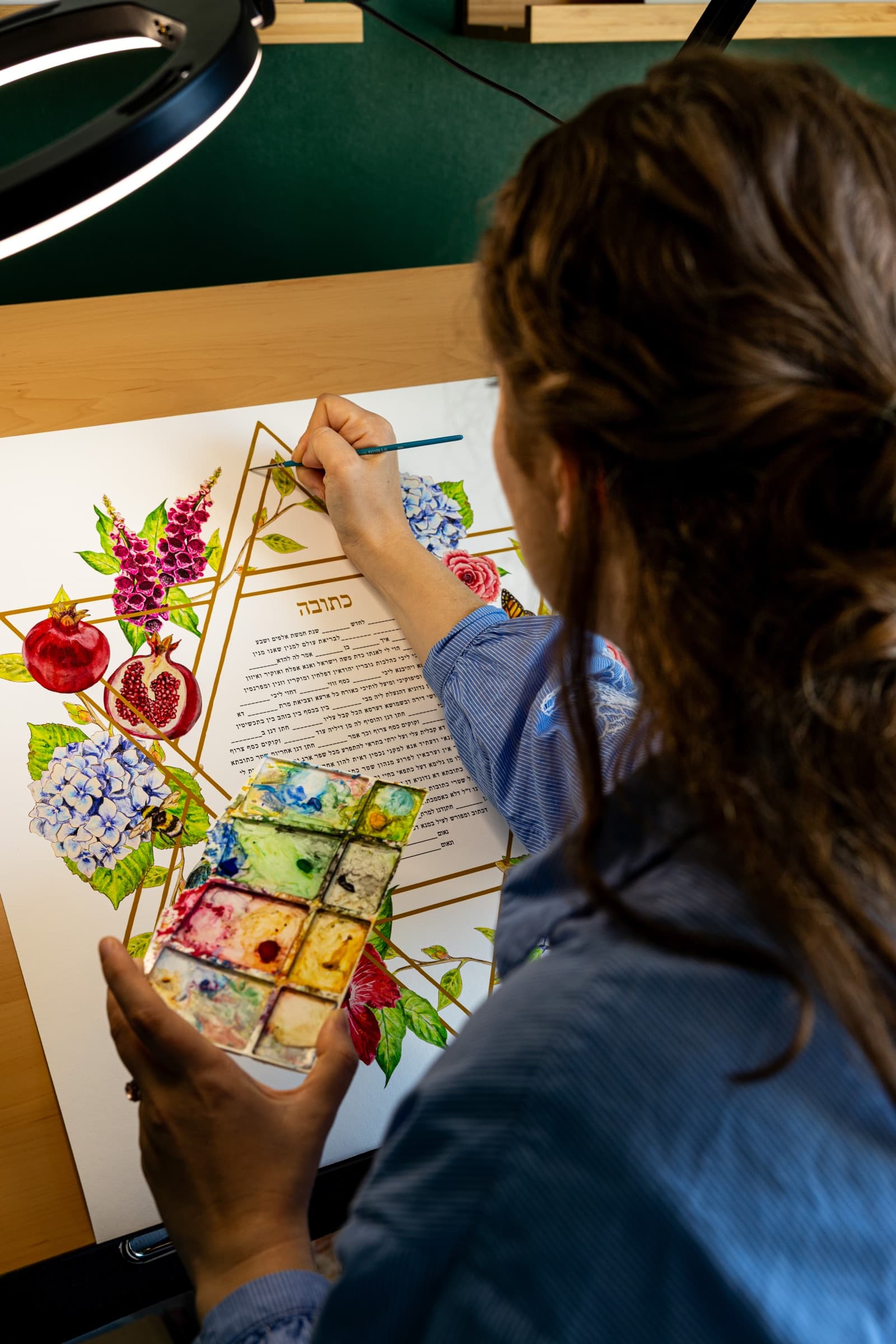 Sophie Bacall painting a floral ketubah by hand in her studio
